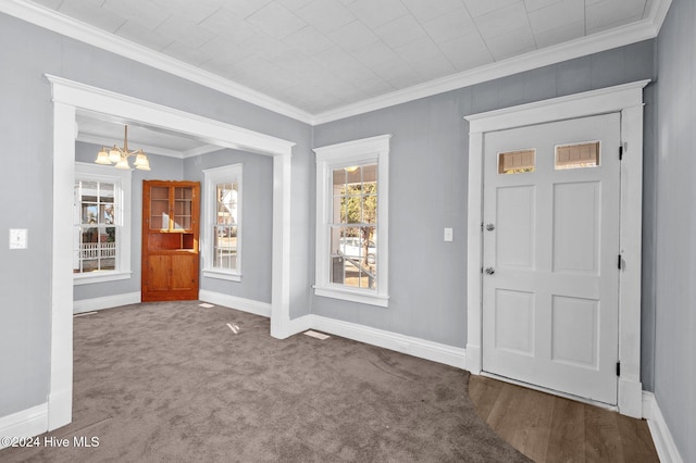 carpeted foyer entrance featuring an inviting chandelier and ornamental molding