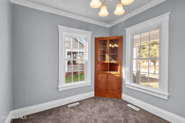 unfurnished dining area with carpet, an inviting chandelier, and crown molding