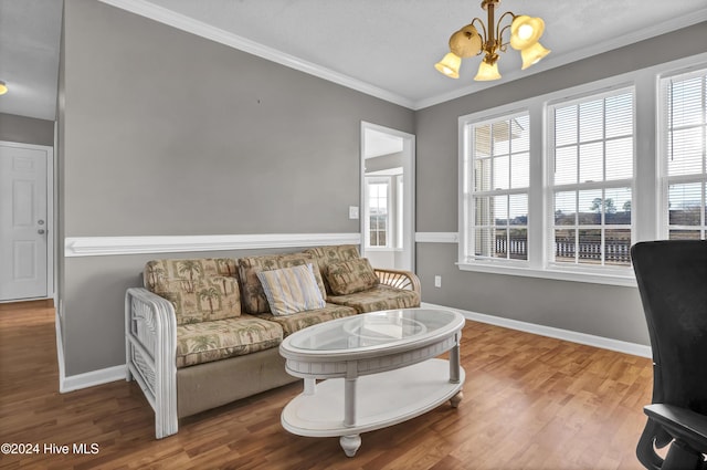 living room featuring hardwood / wood-style floors, a notable chandelier, ornamental molding, and a wealth of natural light