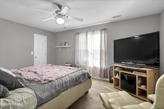 carpeted bedroom with a textured ceiling and ceiling fan