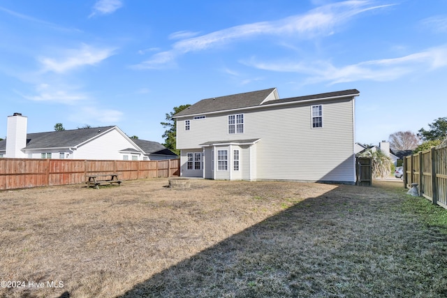 rear view of property with a lawn