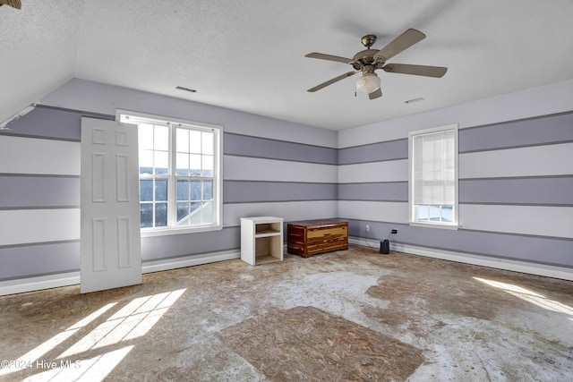 spare room with vaulted ceiling, ceiling fan, and a textured ceiling