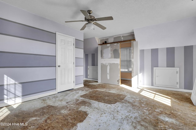 unfurnished living room with ceiling fan and a textured ceiling