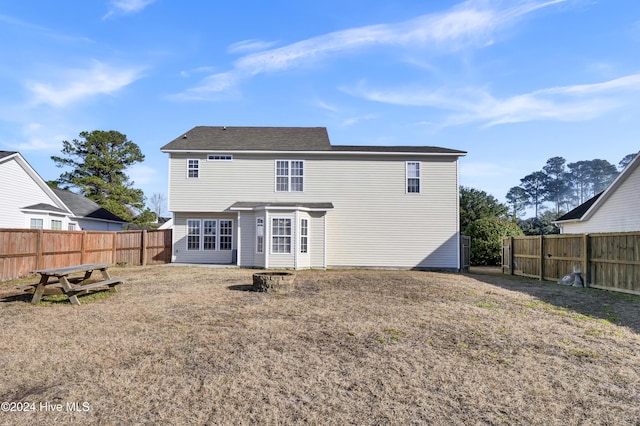 rear view of house featuring a yard