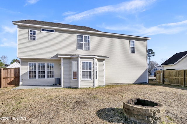 back of property featuring central AC, a fire pit, and a patio area