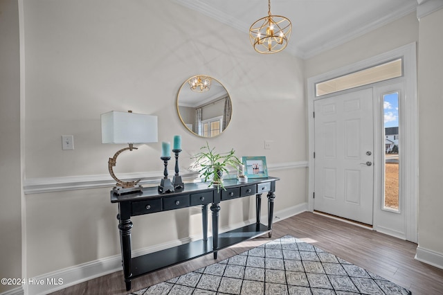 entryway with a chandelier, wood-type flooring, and ornamental molding