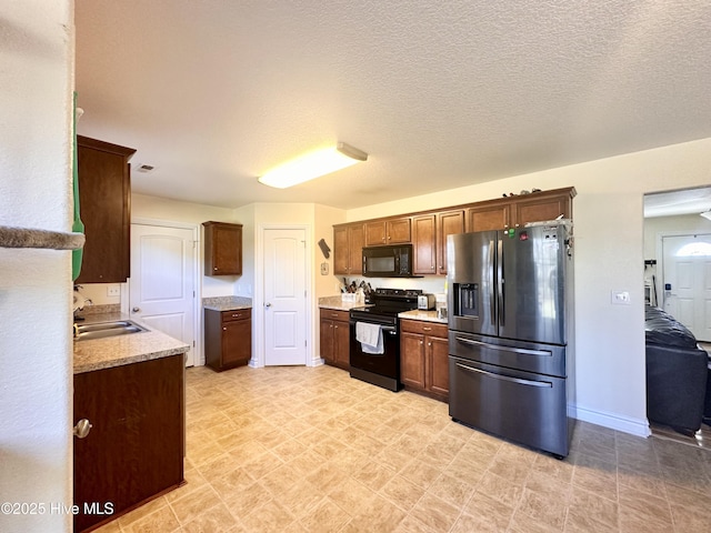 kitchen featuring sink, a textured ceiling, and black appliances