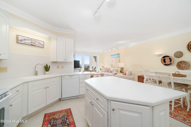 kitchen featuring tasteful backsplash, white dishwasher, a kitchen island, sink, and white cabinetry