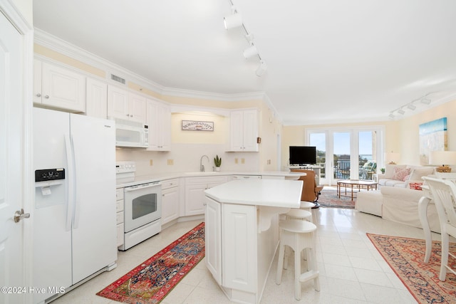 kitchen with a center island, white appliances, white cabinets, a kitchen breakfast bar, and ornamental molding