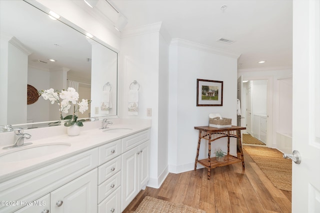 bathroom with hardwood / wood-style floors, vanity, and ornamental molding