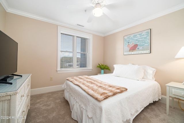 bedroom featuring ceiling fan, crown molding, and light colored carpet