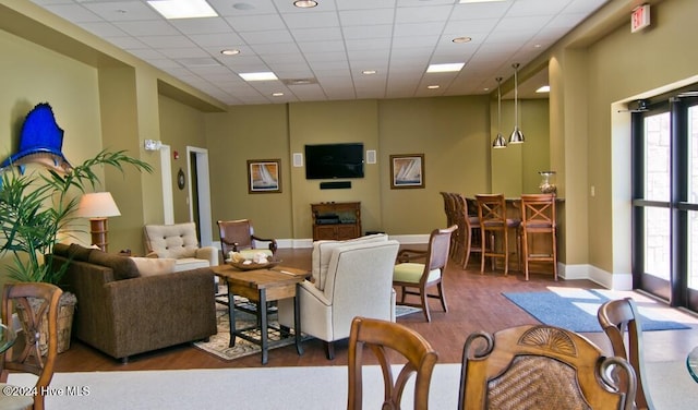 living room with a drop ceiling and hardwood / wood-style floors