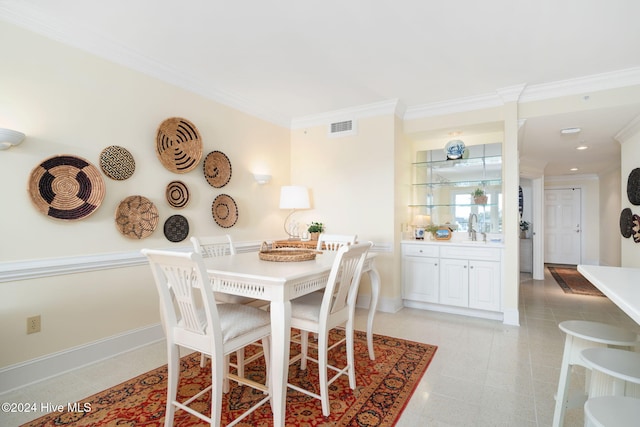 dining room with ornamental molding and sink