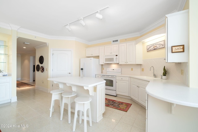 kitchen with white cabinetry, a center island, sink, white appliances, and a breakfast bar