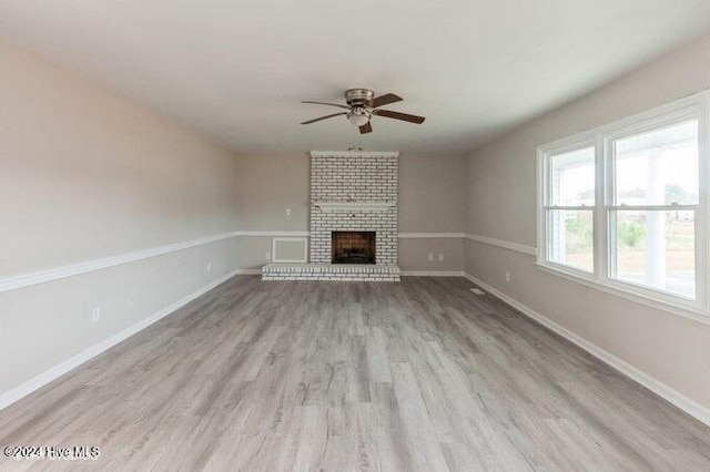 unfurnished living room featuring ceiling fan, light hardwood / wood-style flooring, and a brick fireplace