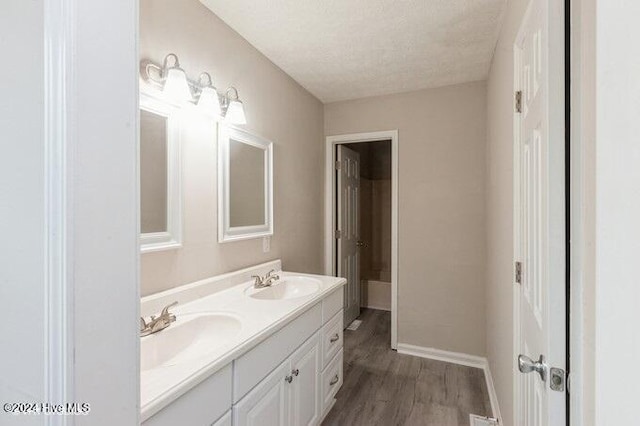 bathroom featuring hardwood / wood-style floors, vanity, and a textured ceiling