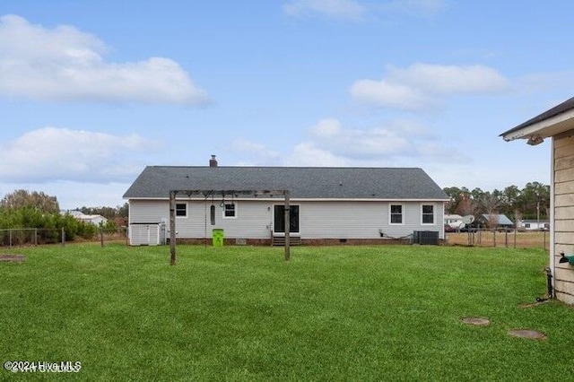 back of property featuring central AC and a yard