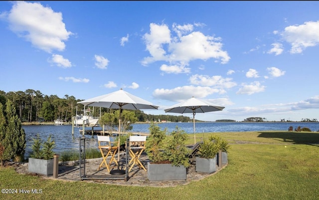 view of dock with a lawn and a water view