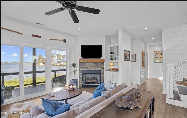 living room featuring hardwood / wood-style floors, ceiling fan, and ornamental molding