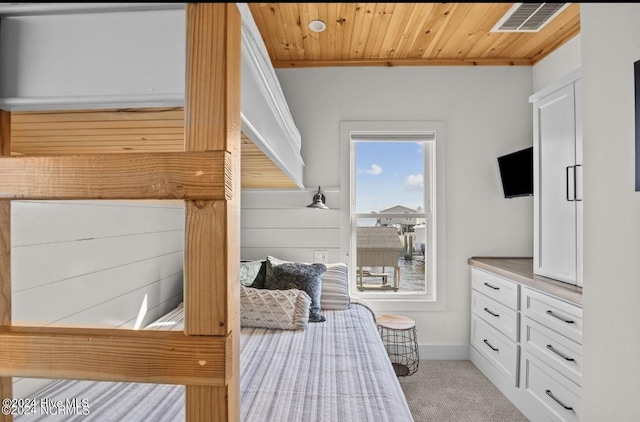 bedroom with wooden ceiling and light carpet