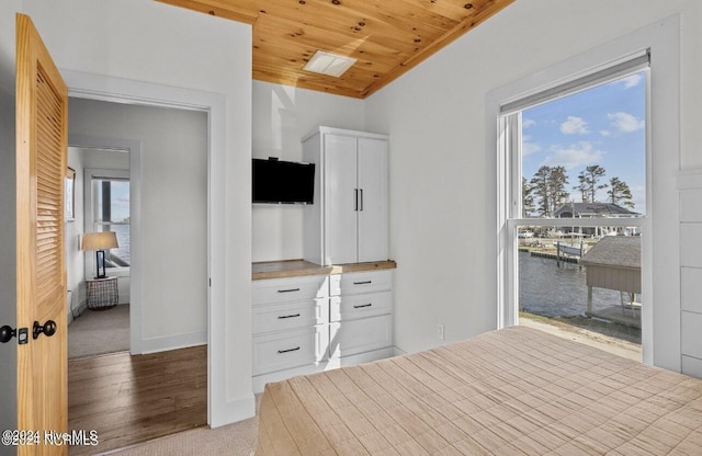 unfurnished bedroom with light wood-type flooring, multiple windows, ornamental molding, and wood ceiling