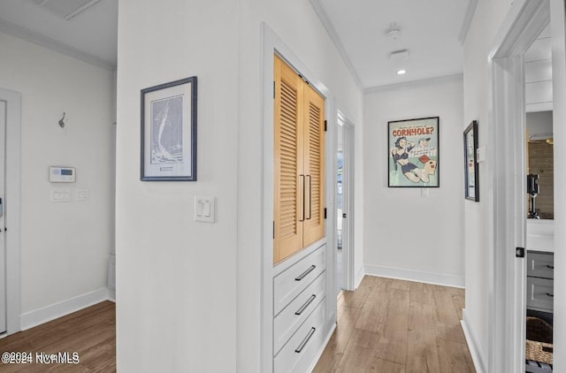 hallway featuring light wood-type flooring and ornamental molding