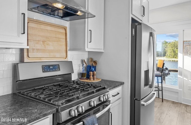 kitchen with white cabinetry, stainless steel appliances, and extractor fan