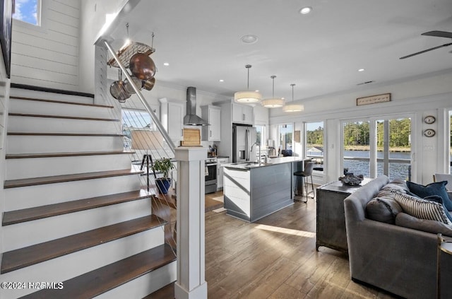 living room with dark hardwood / wood-style floors, ceiling fan, sink, and crown molding