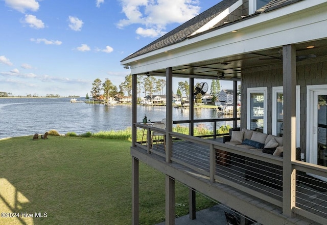 dock area with an outdoor living space, a yard, and a water view