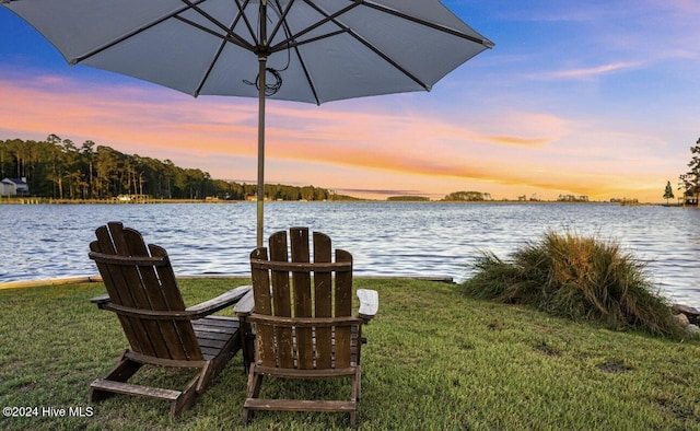 view of dock featuring a lawn and a water view