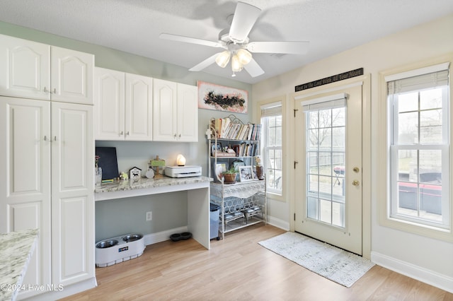 entryway featuring a textured ceiling, light wood-type flooring, and ceiling fan