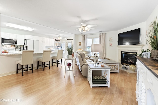 living room featuring ceiling fan and light hardwood / wood-style floors