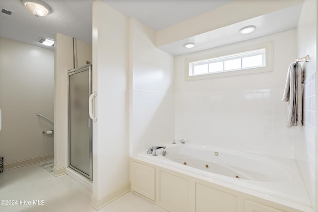 bathroom featuring plus walk in shower and a textured ceiling