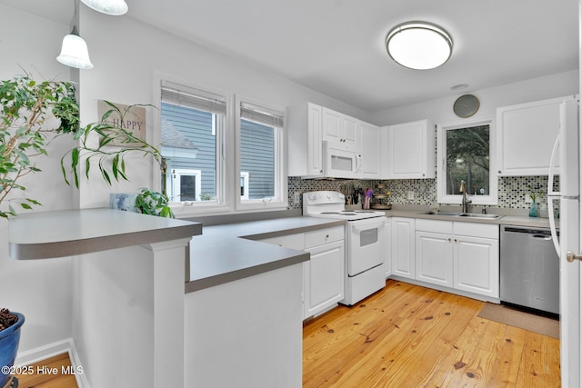 kitchen with white appliances, white cabinets, sink, light hardwood / wood-style flooring, and decorative light fixtures