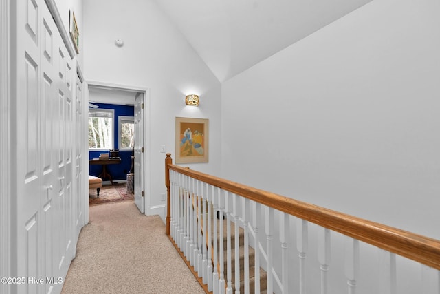 corridor featuring light carpet and vaulted ceiling