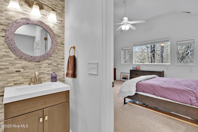 carpeted bedroom featuring vaulted ceiling, ceiling fan, and sink