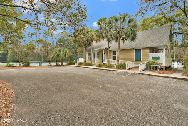 view of front of house with tennis court