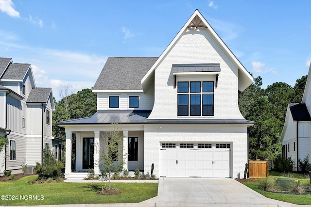 modern farmhouse featuring a front lawn and a garage