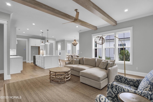 living room with beamed ceiling, ceiling fan with notable chandelier, light hardwood / wood-style flooring, and a wealth of natural light