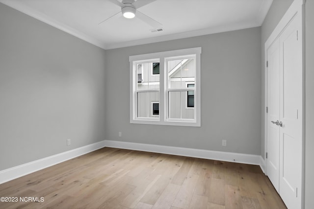 empty room with ceiling fan, light hardwood / wood-style flooring, and ornamental molding