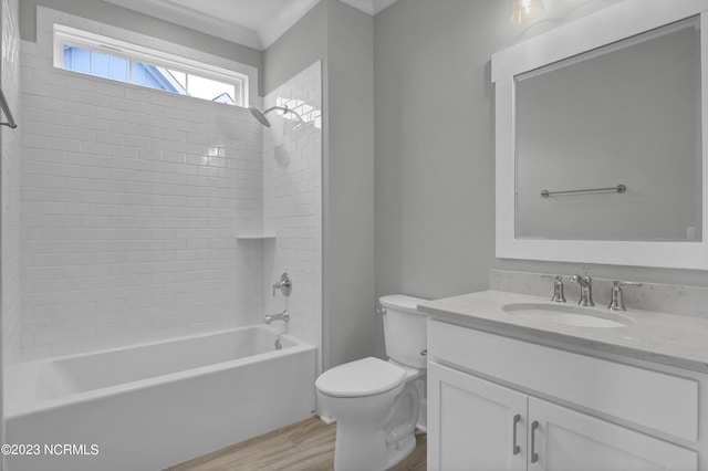 full bathroom featuring ornamental molding, hardwood / wood-style floors, toilet, vanity, and tiled shower / bath