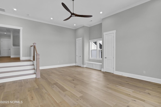 unfurnished living room with a towering ceiling, light hardwood / wood-style floors, ceiling fan, and ornamental molding