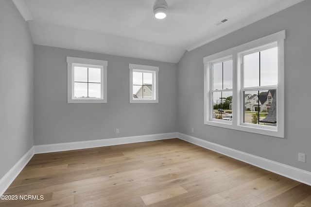 empty room featuring light hardwood / wood-style floors and vaulted ceiling