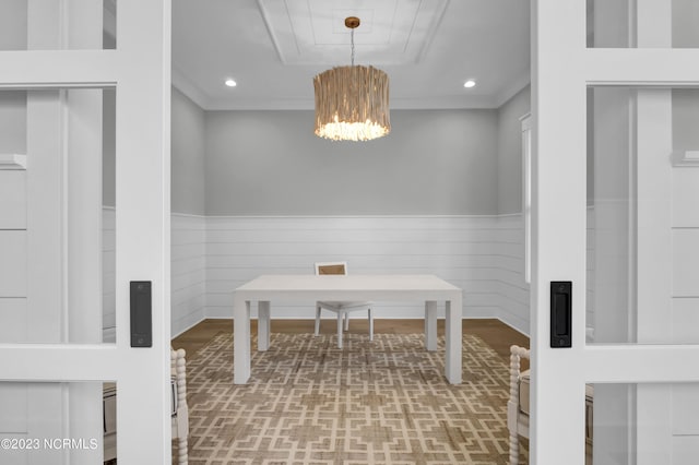 office space featuring a chandelier, hardwood / wood-style floors, crown molding, and wooden walls