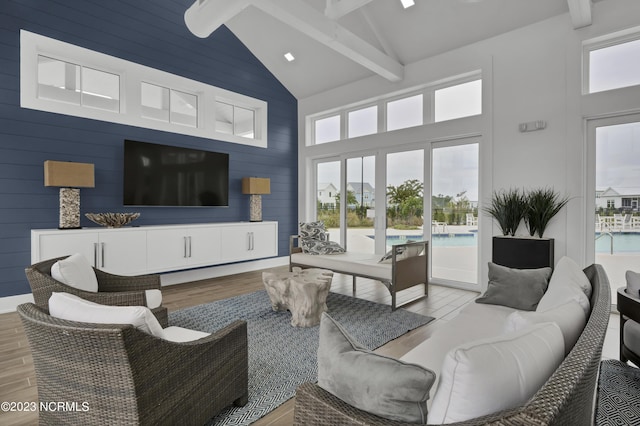 living room with beam ceiling, light hardwood / wood-style flooring, and high vaulted ceiling