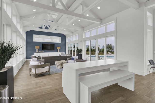 living room with beam ceiling, high vaulted ceiling, and light wood-type flooring