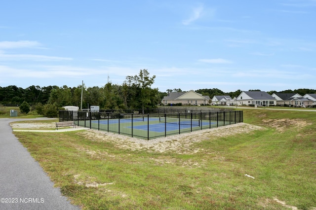 view of swimming pool with a yard and tennis court