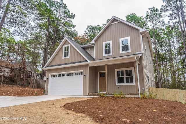 view of front of house with board and batten siding, fence, a porch, roof with shingles, and driveway