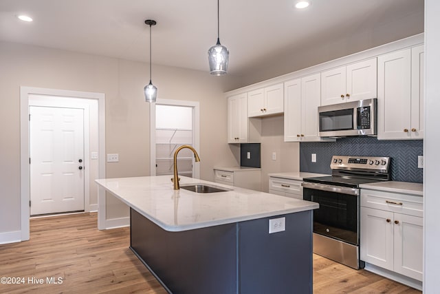 kitchen featuring a sink, tasteful backsplash, white cabinetry, appliances with stainless steel finishes, and light wood finished floors