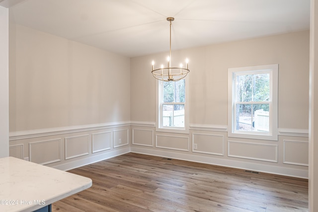 1725 Longleaf Dr E, Pinehurst, NC 28374 - unfurnished dining area with plenty of natural light, wainscoting, wood finished floors, and a chandelier